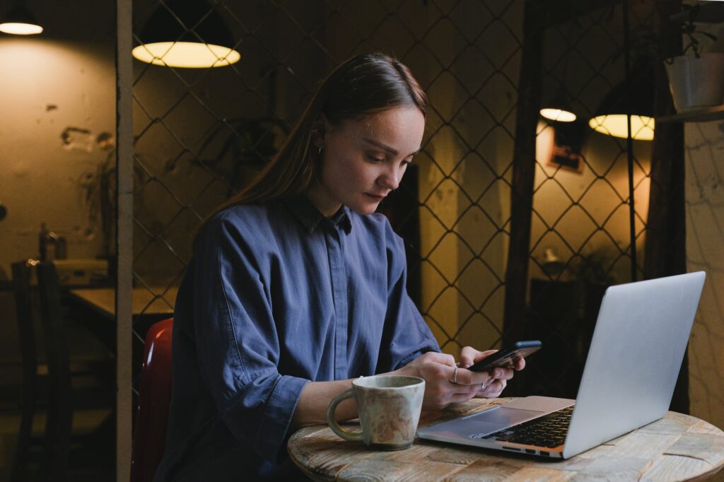 focused woman messaging on smartphone at table in cafe