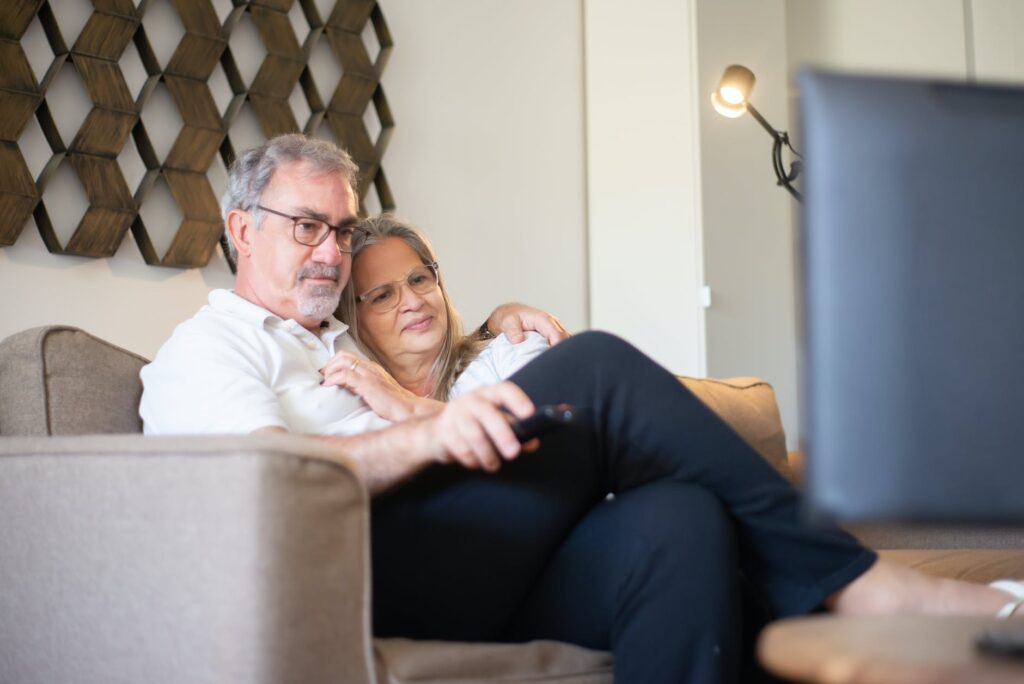 an eldery couple watching television together